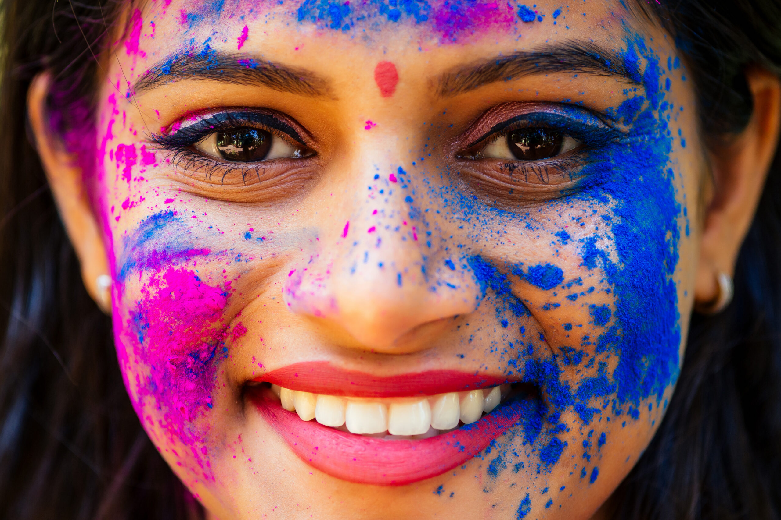 Holi Festival Of Colours. Portrait of happy indian girl in traditional hindu sari on holi color . india woman silver jewelry with powder paint on dress ,colorful pink and blue hair in Goa Kerala